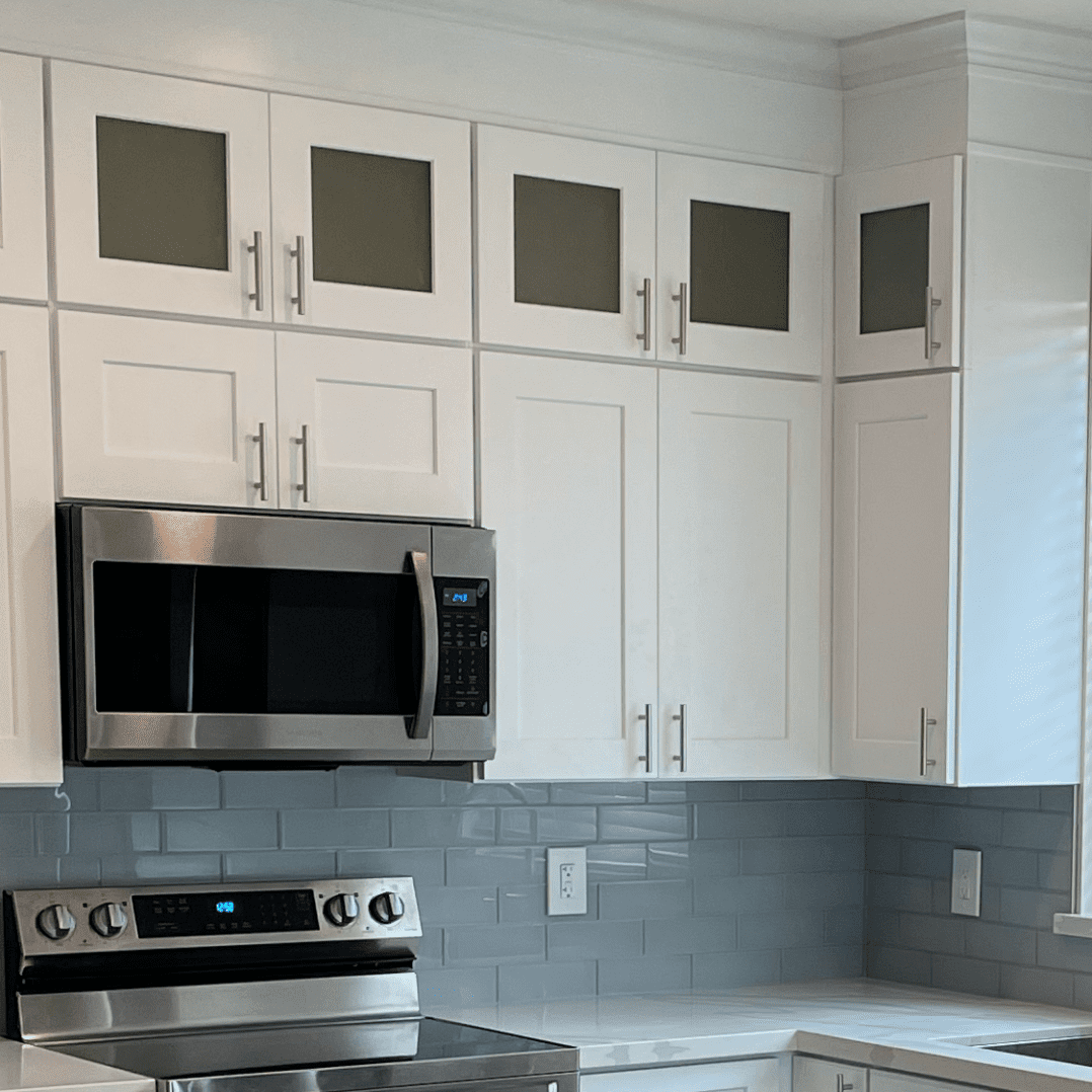 A kitchen with white cabinets and stainless steel appliances.