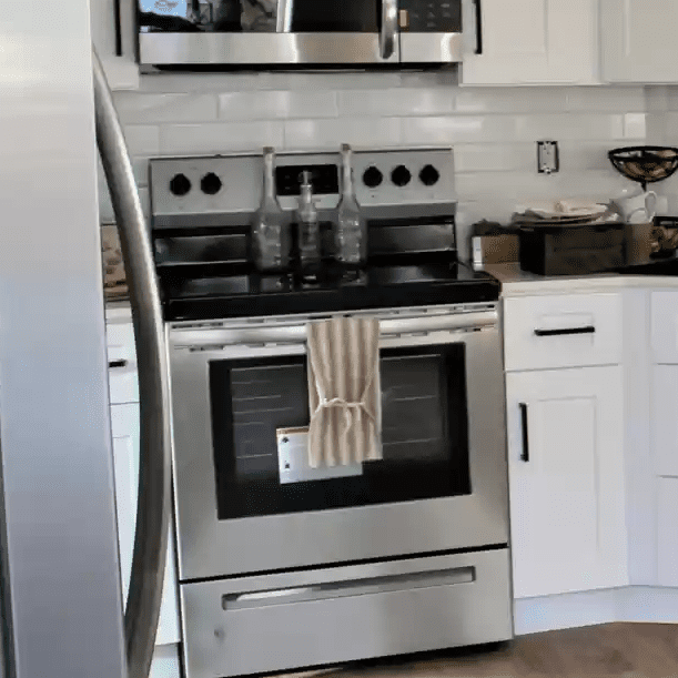 A kitchen with stainless steel appliances and white cabinets.